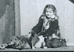 Pam Doan on front porch with Sparky and the three legged cat Tom.