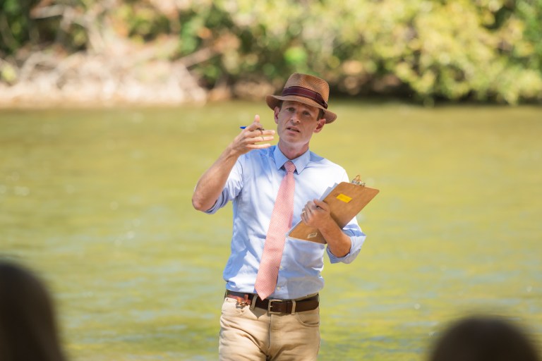 Photo of Bob holding a clipboard and gesturing.